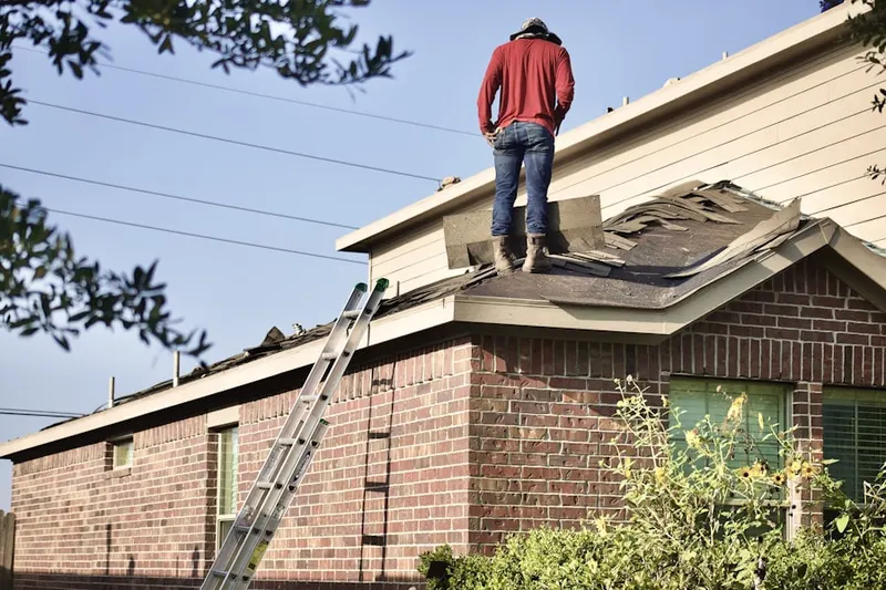 Professional roofer working on a residential roof in Lents